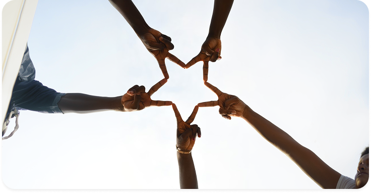 Hands forming a star against the sky